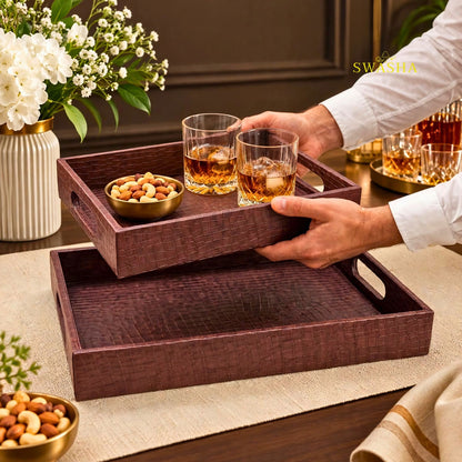 Burgundy faux leather serving tray set of 2 with crocodile texture on coffee table with whiskey glasses and flowers